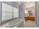 Bathroom with a large soaking tub, vanity with mirror, and tile flooring at 18823 Wimbledon Cir, Lutz, FL 33558