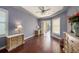 Bedroom with hardwood floors, a tray ceiling, a ceiling fan, and sliding glass doors to a balcony at 18823 Wimbledon Cir, Lutz, FL 33558