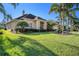 Beautiful home with a green lawn, lush landscaping, and mature palm trees at 18823 Wimbledon Cir, Lutz, FL 33558