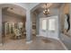 Elegant foyer with double doors, tile flooring, arched doorways, and chandelier lighting at 18823 Wimbledon Cir, Lutz, FL 33558