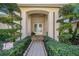 Arched front entryway featuring sculpted landscaping and a decorative walkway at 18823 Wimbledon Cir, Lutz, FL 33558