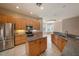Bright kitchen featuring wood cabinetry, granite countertops, stainless steel appliances, and an island at 18823 Wimbledon Cir, Lutz, FL 33558