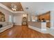 Open concept living area with hardwood floors, tray ceiling, and partial view of the kitchen at 18823 Wimbledon Cir, Lutz, FL 33558
