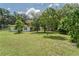 Large backyard featuring lawn and shady trees at 2708 De Montmollin Rd, Plant City, FL 33565