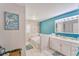 Bathroom with modern blue accent wall, soaker tub, white vanity, drawers, and decorative elements at 2708 De Montmollin Rd, Plant City, FL 33565