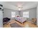 Cozy bedroom features hardwood floors, a ceiling fan, and windows that fill the room with natural light at 2708 De Montmollin Rd, Plant City, FL 33565