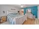 Bright bedroom featuring hardwood floors, a ceiling fan, blue accent wall, and white furniture at 2708 De Montmollin Rd, Plant City, FL 33565