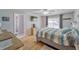 Cozy bedroom boasts hardwood floors, a ceiling fan, natural light, and a connected bathroom at 2708 De Montmollin Rd, Plant City, FL 33565