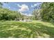 Well-maintained home featuring a spacious green lawn, fenced yard, and mature trees providing privacy and a tranquil setting at 2708 De Montmollin Rd, Plant City, FL 33565
