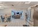 Open floor plan showcasing the living room connected to the kitchen, featuring tile flooring and stainless steel appliances at 2708 De Montmollin Rd, Plant City, FL 33565