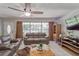 Comfortable living room featuring neutral tones, tile flooring, a ceiling fan, and ample natural light from large windows at 2708 De Montmollin Rd, Plant City, FL 33565