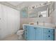 Cozy bathroom featuring a blue vanity, shower, and tile flooring, combining style and functionality at 30 80Th Ter, Treasure Island, FL 33706