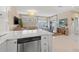 Open-concept kitchen flows to the dining area, featuring modern appliances, natural light, and counter seating at 30 80Th Ter, Treasure Island, FL 33706