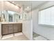 Modern bathroom with dual sink vanity, a glass shower with a pebble floor and a large, bright window at 3115 Bent Creek Dr, Valrico, FL 33596