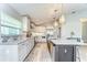 Bright kitchen boasts gray cabinets, stainless appliances, and island with a farmhouse sink and modern pendant lights at 3115 Bent Creek Dr, Valrico, FL 33596