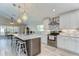 The spacious kitchen features white cabinetry, stainless steel appliances, a large island, and stylish pendant lighting at 3115 Bent Creek Dr, Valrico, FL 33596