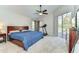 Spacious main bedroom features a ceiling fan, en-suite bathroom, and sliding glass doors to the outdoor pool area at 3115 Bent Creek Dr, Valrico, FL 33596
