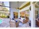 Covered patio with wicker furniture, ceiling fan, brick pavers, and sliding glass doors to the interior at 3115 Bent Creek Dr, Valrico, FL 33596