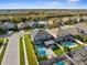 Aerial view of a backyard with a pool, a fire pit, and outdoor furniture, nestled in a community setting at 3654 Beneraid St, Land O Lakes, FL 34638