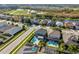 An aerial view of a backyard pool and outdoor seating area, in a neighborhood near a small lake at 3654 Beneraid St, Land O Lakes, FL 34638