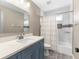Bathroom featuring blue vanity with quartz countertops, shower and mosaic tile accents at 3654 Beneraid St, Land O Lakes, FL 34638