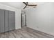 Bright bedroom with grey hardwood flooring, closet, and ceiling fan at 3654 Beneraid St, Land O Lakes, FL 34638