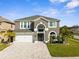 Stunning two-story home boasts a modern design, well-manicured lawn, and elegant paver driveway at 3654 Beneraid St, Land O Lakes, FL 34638