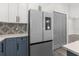 Kitchen featuring modern stainless refrigerator and cabinets with contrasting backsplash at 3654 Beneraid St, Land O Lakes, FL 34638