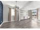 Bright living room featuring a modern light fixture, hardwood floors, and large windows at 3654 Beneraid St, Land O Lakes, FL 34638