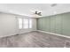 Living room featuring shiplap accent wall, window with blinds, and hardwood flooring at 3654 Beneraid St, Land O Lakes, FL 34638
