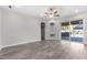 Open living room featuring wood floors, recessed lighting, and a sliding door to an outdoor entertainment area at 3654 Beneraid St, Land O Lakes, FL 34638