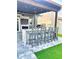 Stylish outdoor kitchen bar with seating and a built-in grill under a covered patio at 3654 Beneraid St, Land O Lakes, FL 34638