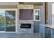Cozy outdoor fireplace and mounted TV set in a stone surround near the outdoor kitchen and sliding door at 3654 Beneraid St, Land O Lakes, FL 34638