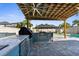 Beautiful outdoor kitchen with a built in grill, refrigerator, and marble countertops, perfect for entertaining at 3654 Beneraid St, Land O Lakes, FL 34638
