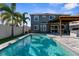 Backyard featuring a sparkling pool, pergola covered outdoor kitchen, a fire pit and lush landscaping for privacy at 3654 Beneraid St, Land O Lakes, FL 34638