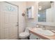 Well-lit bathroom with a toilet, sink and cabinet, and a door to the exterior at 36745 Kimela Ave, Zephyrhills, FL 33542