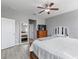 Bright main bedroom showcasing wood floors, neutral paint, ceiling fan, and a king bed with bench at 445 Bahama Grande Blvd, Apollo Beach, FL 33572