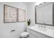 Stylish half bathroom with a modern mirror, vanity, and unique abstract art at 4511 S Manhattan Ave # 32, Tampa, FL 33611