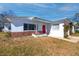 Charming single-story home featuring a red front door, a small porch, and brick accent details at 479 80Th Way, St Pete Beach, FL 33706