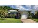 Charming single-story home featuring a red door and a well-maintained lawn, providing great curb appeal at 479 80Th Way, St Pete Beach, FL 33706