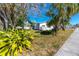 Well-maintained front yard with mature trees, complemented by a charming home exterior at 479 80Th Way, St Pete Beach, FL 33706