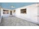 Sun room with a blue ceiling, white walls, tile floor and bright windows at 479 80Th Way, St Pete Beach, FL 33706