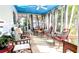Charming sunroom with a blue ceiling, offering an airy space with abundant natural light and comfortable seating at 479 80Th Way, St Pete Beach, FL 33706