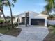 Modern home boasts clean lines, stone accents, and a stylish paved driveway, enhanced by lush palm trees at 4907 15Th N Ave, St Petersburg, FL 33710