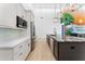 Bright kitchen with white cabinets, stainless steel appliances, and an island with dark counter and mural at 4907 15Th N Ave, St Petersburg, FL 33710