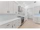 Bright kitchen boasts white cabinets and countertops, stainless steel appliances, and modern finishes at 4907 15Th N Ave, St Petersburg, FL 33710