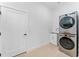 Laundry room with stacked washer and dryer, utility sink, and door at 4907 15Th N Ave, St Petersburg, FL 33710