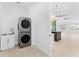 Bright laundry area with stacked washer/dryer, utility sink, and adjacent open living space at 4907 15Th N Ave, St Petersburg, FL 33710