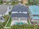 Aerial view of a modern home showcasing a backyard with a swimming pool, lush landscaping, and a spacious patio area at 5017 W Dickens Ave, Tampa, FL 33629