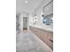 Luxurious bathroom with marble floors, glass shower, modern vanity with dual sinks, and stylish lighting at 5017 W Dickens Ave, Tampa, FL 33629
